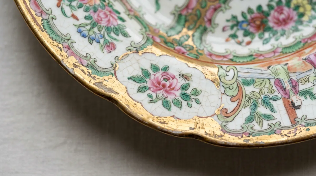 Macro of a plate rim showing gilt wear and hand-painted brushwork